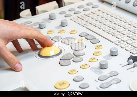 Doctor using medical ultrasound equipment, USG, clinic specialist performing diagnostic ultrasound imaging, machine closeup, technology, hand detail, Stock Photo