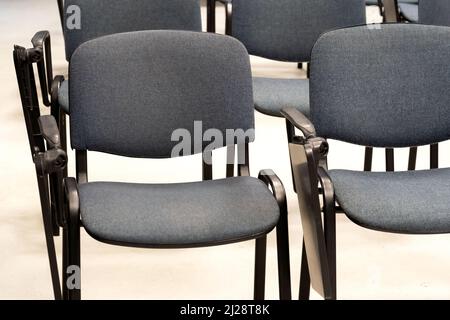 Empty chairs with foldable desks at a lecture hall, vacant course, seminar room, class, business school, nobody, empty seats, no people at the univers Stock Photo