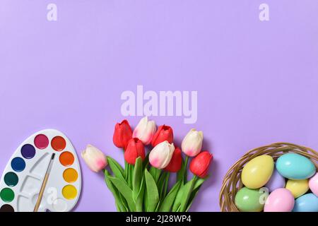 Easter background with painted eggs, paints and tulips. Copy space. Stock Photo