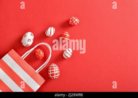Paper eco-bag with painted Easter eggs on a red background. Stock Photo