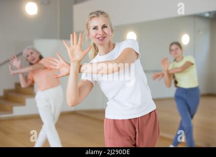 Woman performing aerobic dance during group training Stock Photo