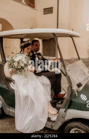 The bride and the groom riding in golf card at wedding reception Stock ...
