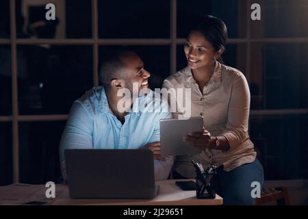 Thank you for thinking about me. Shot of a young couple using a digital tablet together at night. Stock Photo