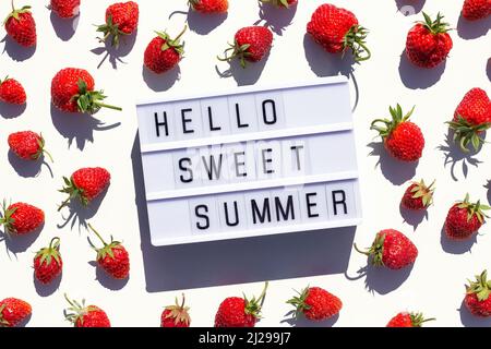 Hello Sweet Summer text on light box and strawberry on white background. Creative concept Summer time. Top view, Flat lay, greeting card. Stock Photo