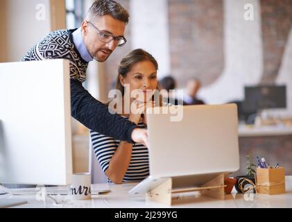 Collaborating on a project. Shot of two designers working together at a computer. Stock Photo