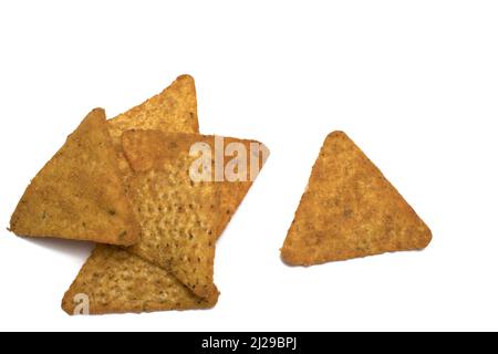 Close up of stack of triangular golden brown crispy fried tortilla chips and single piece next to it on white background Stock Photo
