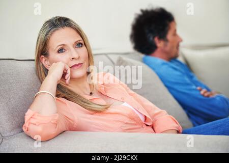 Is it even worth fighting anymore. Shot of a mature couple not speaking to each other after a disagreement at home. Stock Photo