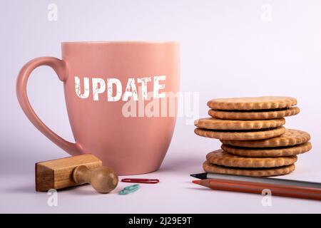 Update, business concept. Coffee mug, cookies and office supplies on a white background. Stock Photo
