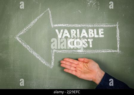 VARIABLE COST. Text and arrow on a green chalkboard. Stock Photo