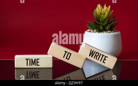 Text Time To Write Lettering Wooden Blocks on red and black background with cactus flower. Business Concept Stock Photo