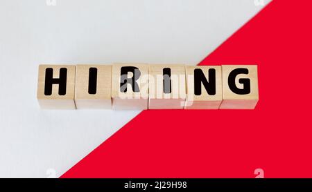 HIRE word made from building blocks on red and white background Stock Photo