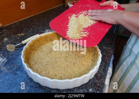 Southern German cuisine, baking, preparation of hearty vegetable cake with walnut base, walnut dough in the baking tin, tart tin, quiche tin, pastry Stock Photo