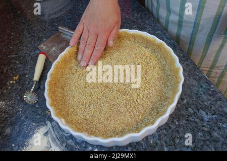 Southern German cuisine, baking, preparation of hearty vegetable cake with walnut base, walnut dough in the baking tin, tart tin, quiche tin, pastry Stock Photo