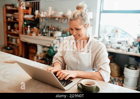 Im trying to keep up with my online sales. Cropped shot of a artisan using a laptop in her workshop. Stock Photo