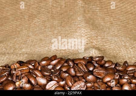 Coffee beans of the Arabica variety lie in a jute bag Stock Photo