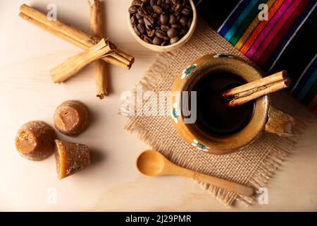 https://l450v.alamy.com/450v/2j29pmr/cafe-de-olla-traditional-mexican-coffee-and-basic-ingredients-for-its-preparation-coffee-cinnamon-and-piloncillo-served-in-a-clay-cup-called-jarr-2j29pmr.jpg