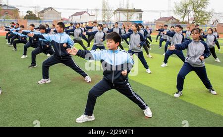 HAI'AN, CHINA - MARCH 31, 2022 - Photo taken on March 31, 2022 shows students practicing martial arts on the playground of Huji Junior High School in Stock Photo
