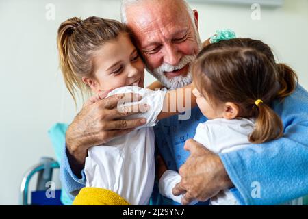 Happy laughing grandfather playing, having fun with his grandchildren together. Stock Photo
