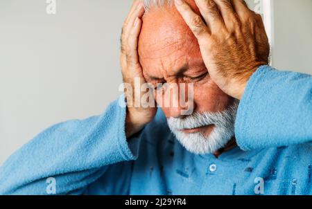 Senior man suffering from headache. Healthcare illness people concept Stock Photo