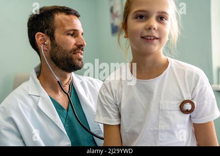 Healthcare medical exam people child concept. Close up of happy girl and doctor with stethoscope Stock Photo