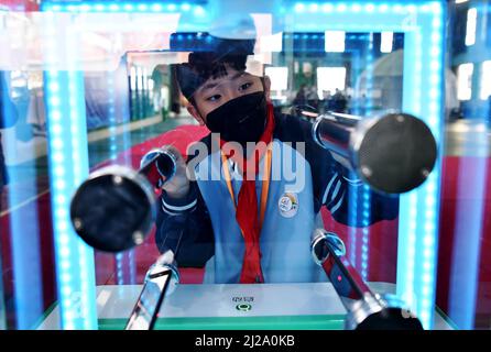 ZHANGJIAKOU, CHINA - MARCH 31, 2022 - A primary school student experiences the charm of technology at the China Mobile Science and Technology Museum i Stock Photo