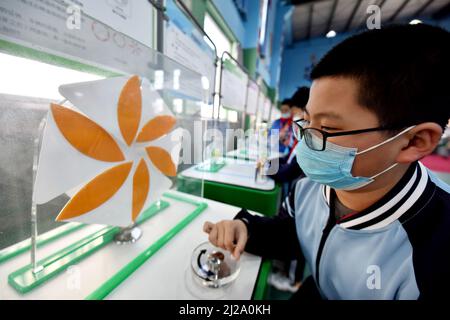 ZHANGJIAKOU, CHINA - MARCH 31, 2022 - A primary school student experiences the charm of technology at the China Mobile Science and Technology Museum i Stock Photo