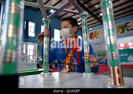 ZHANGJIAKOU, CHINA - MARCH 31, 2022 - A primary school student experiences the charm of technology at the China Mobile Science and Technology Museum i Stock Photo