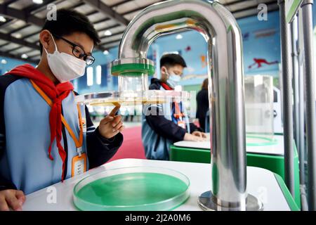 ZHANGJIAKOU, CHINA - MARCH 31, 2022 - A primary school student experiences the charm of technology at the China Mobile Science and Technology Museum i Stock Photo