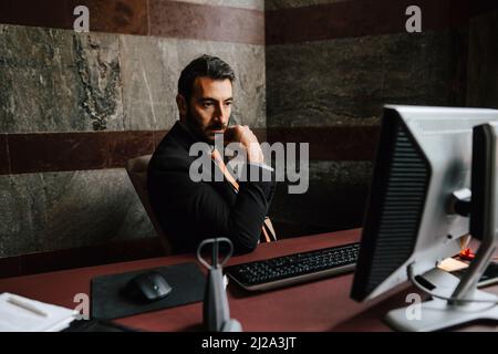 Businessman starting at computer monitor while working in law office Stock Photo