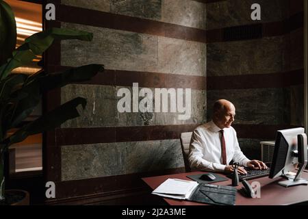 Working senior businessman using computer at law office Stock Photo