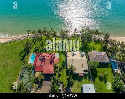 Blacks Beach, Mackay, Queensland, Australia - April 2022: Drone aerial looking down over the roof tops of a tropical resort out to sea on a sunny morn Stock Photo