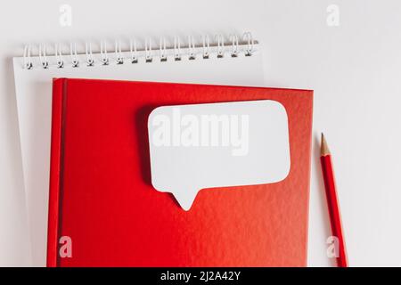 Red notepad and white sticker on the desk. Mock up in copy space office background. It is important not to forget the note Stock Photo