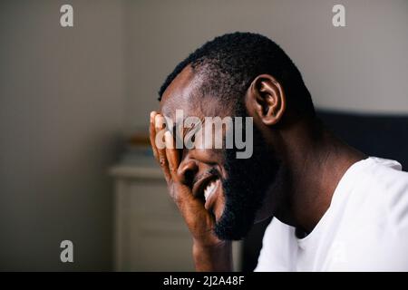 Smiling bearded man hand on with closed eyes at home Stock Photo