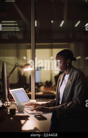 Ambitious working woman using laptop at desk in office Stock Photo