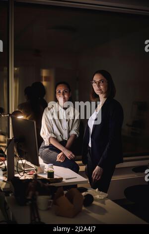 Portrait of multiracial female colleagues in office at night Stock Photo