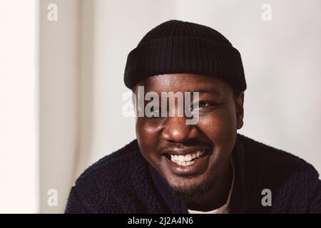 Happy mid adult man looking away against wall Stock Photo