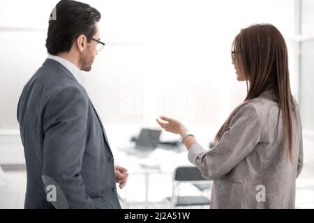rear view.businessman and businesswoman talking standing in the new office Stock Photo