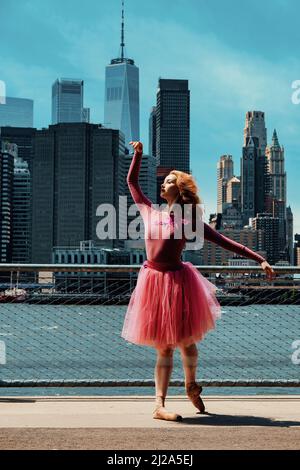 redhead young girl posing at city street downtown New York City financial district ballet tutu Stock Photo