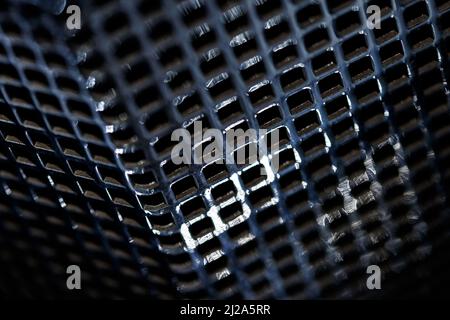 Perspective view on chrome metal grill with selective focus. Small depth of field. Stock Photo
