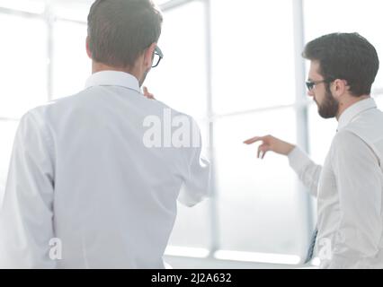 rear view.business partners looking through the office window. Stock Photo
