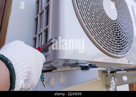 technician installing outdoor air conditioning unit Stock Photo
