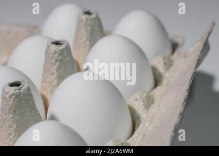 White chicken eggs are in a cardboard box Stock Photo