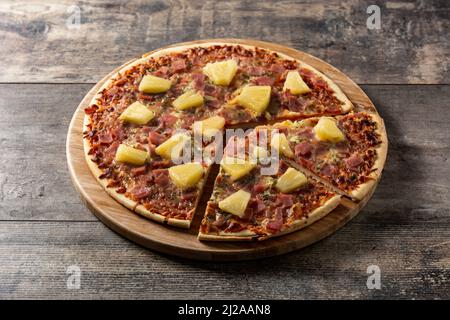 Hawaiian pizza with pineapple,ham and cheese on wooden table Stock Photo