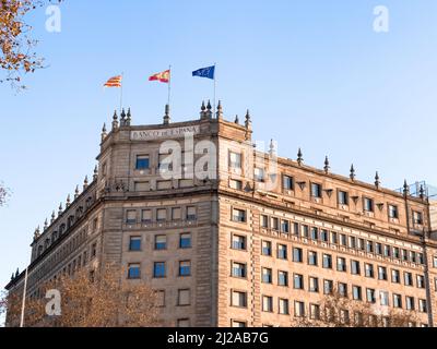 EU, Spanish and Catalan flag fluttering on top of the Spanish bank in Barcelona Stock Photo