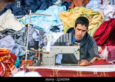 ESSAOUIRA - JAN 03: Man worker sewing clothes at an oriental street market in Medina district in Essaouira, January 03. 2018 in Morocco Stock Photo