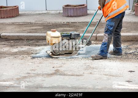 Asphalt vibratory plate compactor. Pothole repair process. Asphalt ...