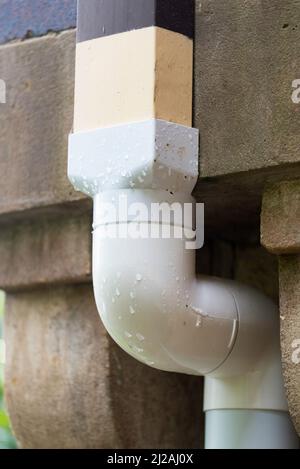 White Unplasticized Polyvinyl Chloride Upvc Downpipe Downspout Attached To A Sandstone Wall