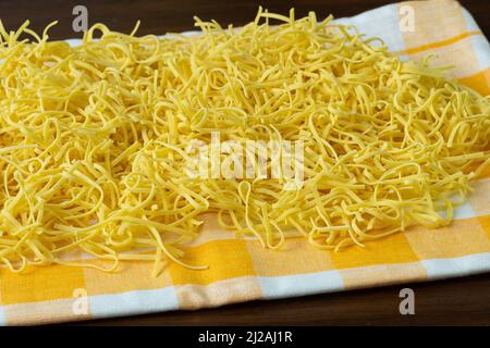 Dry homemade soup noodles. Raw small noodles. Stock Photo