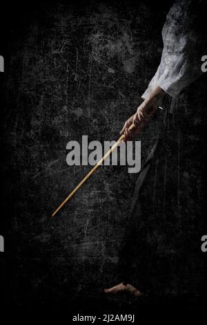 Personl in black hakama standing in fighting pose with wooden sword bokken over dark grunge background. Shallow depth of field. SDF. Stock Photo