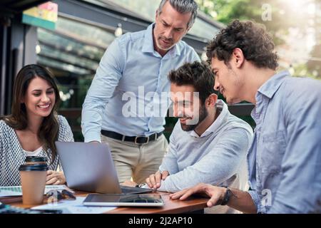 Getting down to business. Cropped shot of a group of business colleagues having a meeting outdoors at a cafe. Stock Photo